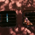 00246_01 An Indian girl peers out of a train window, 1983.