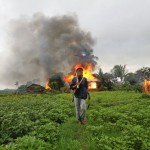 An ethnic Rakhine man holds homemade weapons as he walks in front of houses that were burnt during fighting between Buddhist Rakhine and Muslim Rohingya communities in Sittwe