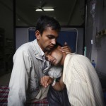 Khilnath, husband of deceased Phuyal, is comforted by a family member at Maternity Hospital in Kathmandu