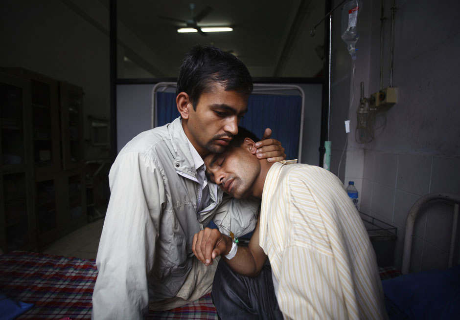 Khilnath, husband of deceased Phuyal, is comforted by a family member at Maternity Hospital in Kathmandu