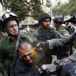 Israeli border police officers use pepper spray as they detain an injured Palestinian protester during clashes outside Jerusalem's Old City