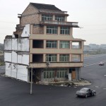 A car stops beside a house in the middle of a newly built road in Wenling