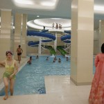 A woman in traditional Korean costume watches as a student leaves a swimming pool of Kim Il-sung University in Pyongyang