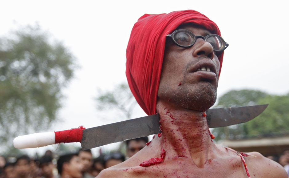 A Hindu devotee with his neck pierced with a knife attends Chadak rituals at Krishanadevpur village