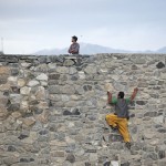 An Afghan man takes a shortcut by climbing a wall, at a hilltop in Kabul