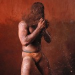 A wrestler rubs his hands with mud to prevent slipping due to sweat, during a traditional mud wrestling bout in Kolhapur