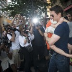 Actor Tom Cruise carries his daughter Suri past a group of photographers as they make their way from a hotel