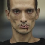 Artist Pavlensky, a supporter of jailed members of female punk band "Pussy Riot" looks on with his mouth sewed up as he protests outside the Kazan Cathedral in St. Petersburg