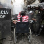 A physically disabled woman on her wheelchair clashes with riot police in the centre of La Paz