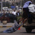 Members of "Field Marshal Hussein Tantawi" try to ride a military police vehicle after a funeral for soldiers in Cairo