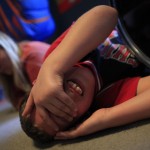 Parker Roos, who suffers from Fragile X, rolls around on the floor after getting into an argument with his sister at their home in Canton, Illinois