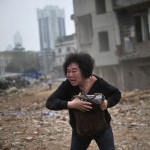 Huang Sufang reacts as she sees a part of her house being taken down by demolition workers at Yangji village in central Guangzhou city