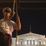 A police officer pretends to hang himself in front of the parliament during a rally in Athens