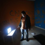 Juan Carlos Castano turns on the TV in his emptied-out bedroom as he waits for the judicial commission to carry out his eviction in Madrid