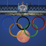 The full moon rises through the Olympic Rings hanging beneath Tower Bridge during the London 2012 Olympic Games