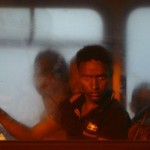 A would-be immigrant looks out of a window on a police bus after arriving at the AFM Maritime Squadron base at Haywharf in Valletta