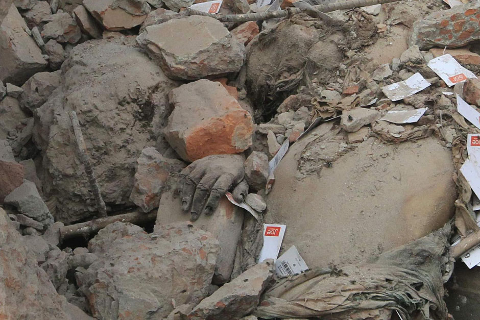 The hand of a garment worker is seen among rubble of collapsed Rana Plaza building in Savar