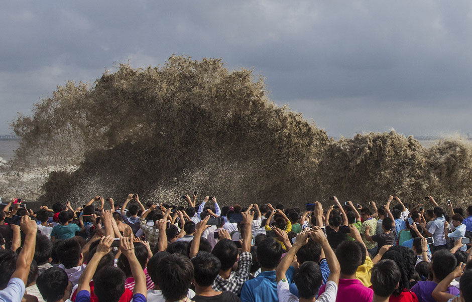 Visitors take pictures of tidal waves under the influence of Typhoon Usagi in Hangzhou