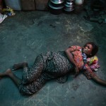 A pregnant Rohingya Muslim woman grimaces while experiencing labour pains at a shelter near Sittwe