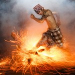 A Balinese man kicks up fire during the "Perang Api" ritual ahead of Nyepi day, in Gianyar, Bali