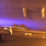 The wrapped bodies of two dead people hang from an overpass as three more dead bodies lie on the ground in Saltillo