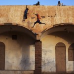 Boys play on the roof of the entrance to a football stadium in Gao