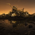 A car rests on top of a pile of debris in an area heavily damaged by a tornado in Moore, Oklahoma