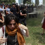 Turkish riot policeman uses tear gas during a protest in central Istanbul