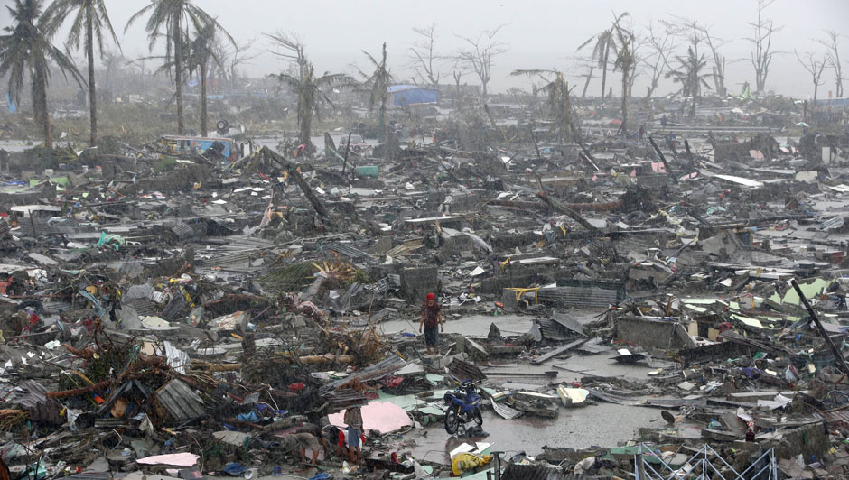 Survivors stand among debris and ruins of houses destroyed after Super Typhoon Haiyan battered Tacloban city in central Philippines