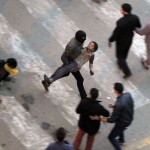 Protesters flee from tear gas fired by riot police during clashes at Qasr al-Aini Street near Tahrir Square in Cairo