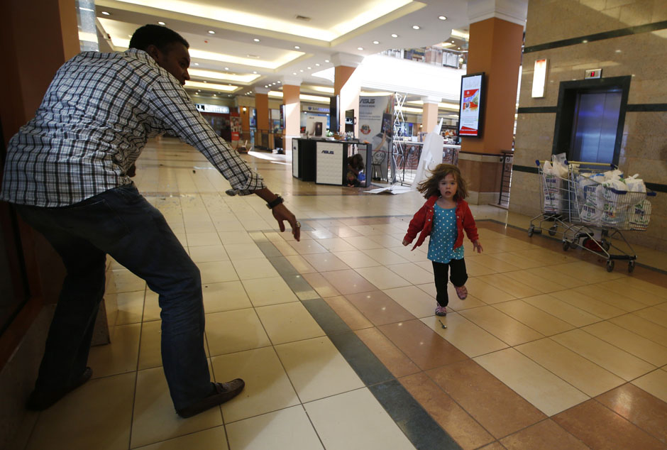 A child runs to safety as armed police hunt gunmen who went on a shooting spree at Westgate shopping centre in Nairobi