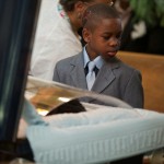 Ronnie Chambers Jr. looks at his mother Tahitah Myles as she collapses during the funeral for his father Ronnie Chambers, 33, a victim of gun violence, in Chicago