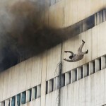 A man falls from a high floor of a burning building in central Lahore