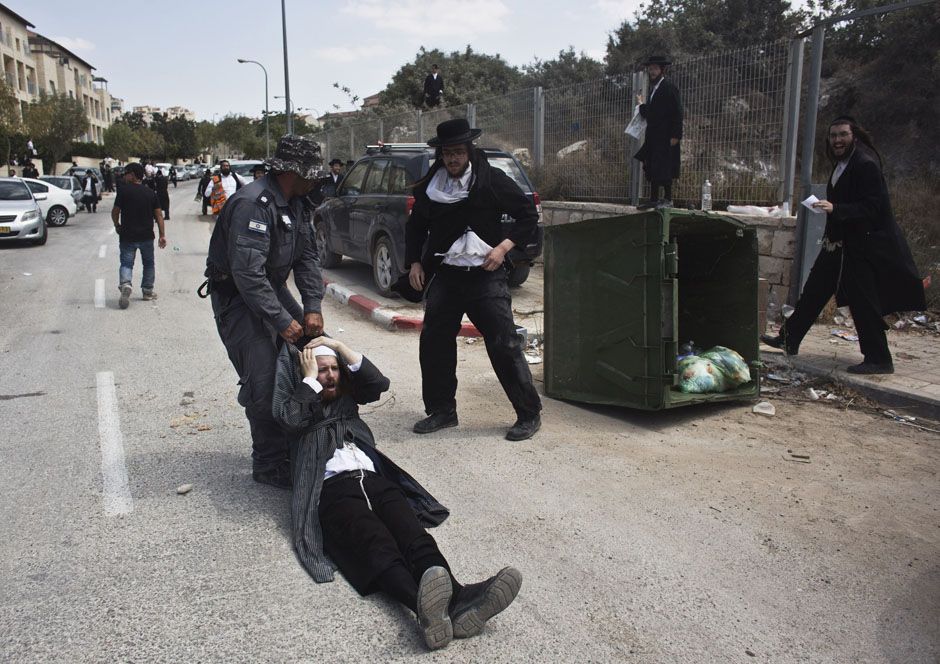 An Israeli policeman drags an ultra-Orthodox man during clashes in the town of Beit Shemesh
