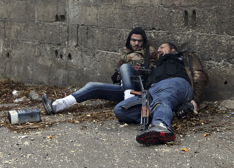 A Free Syrian Army fighter looks at his comrade as he gets shot by sniper fire during heavy fighting in the Ain Tarma neighbourhood of Damascus