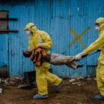 Medical staff carry James Dorbor, 8, suspected of having Ebola, into a treatment facility in Monrovia, Liberia.