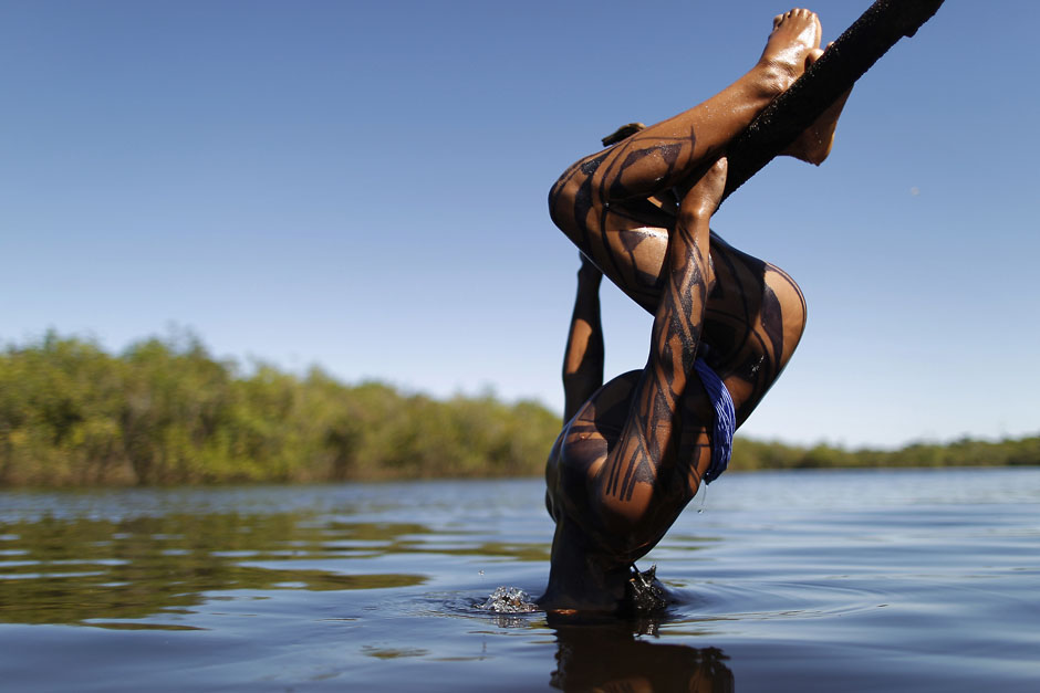 A Yawalapiti boy dips his head into the Xingu River in the Xingu National Park, Mato Grosso State