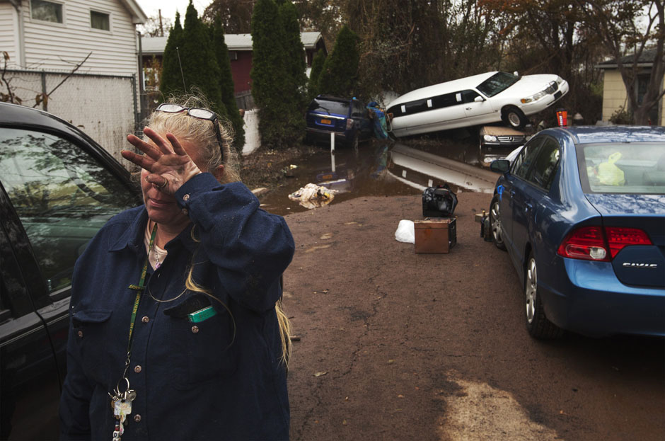 A woman weeps after learning that a neighbor presumed missing is okay while cleaning out her home in a neighborhood heavily damaged by Hurricane Sandy in the New Dorp Beach neighborhood