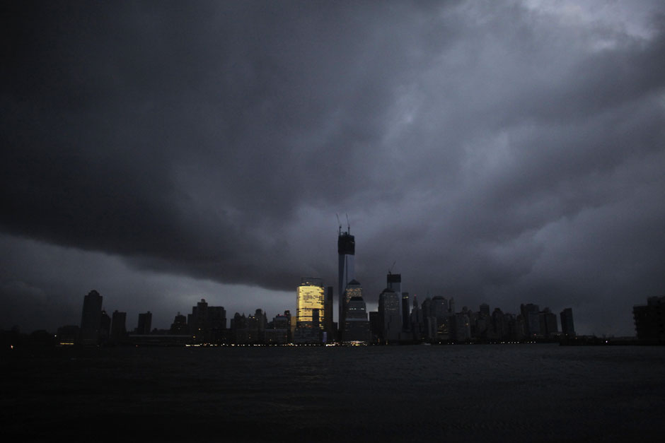 The skyline of lower Manhattan is in darkness except for Goldman Sachs building after a preventive power outage caused by giant storm Sandy as seen from Exchange Place,  in New York