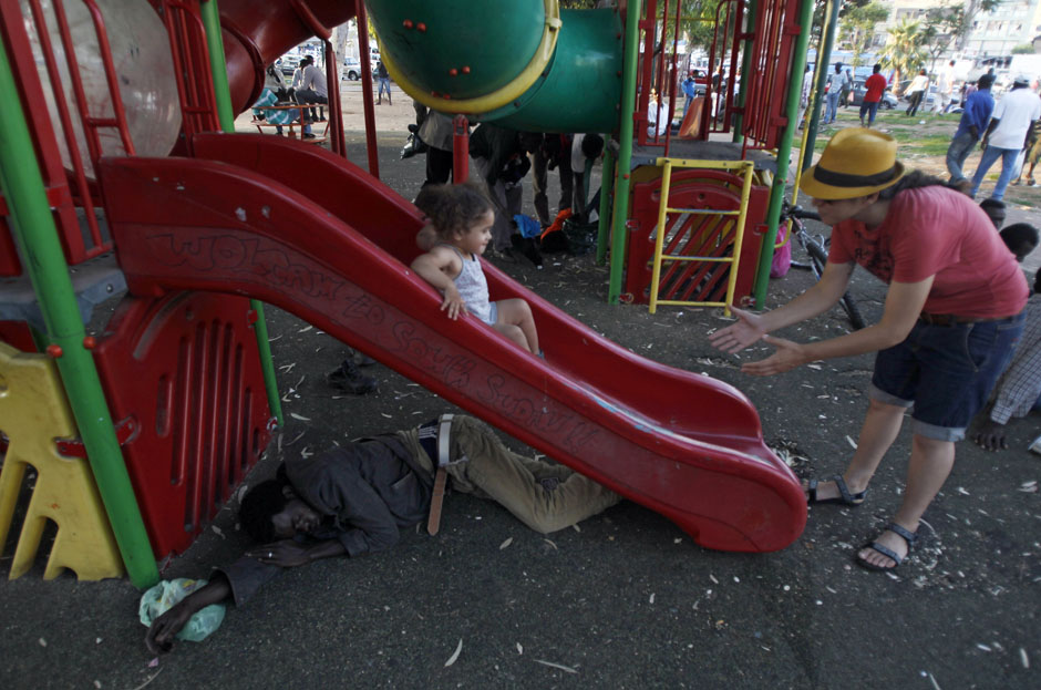 Sudanese migrant sleeps under a slide in South Tel Aviv