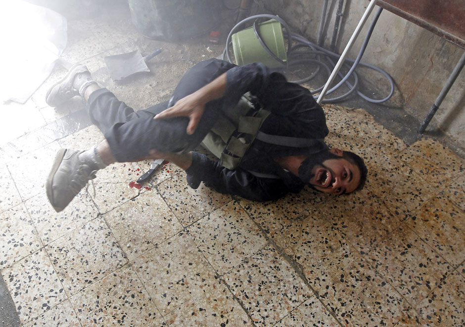 A Free Syrian Army fighter screams in pain after he was injured in a leg by shrapnel from a shell fired from a Syrian Army tank in the Salaheddine neighbourhood of central Aleppo