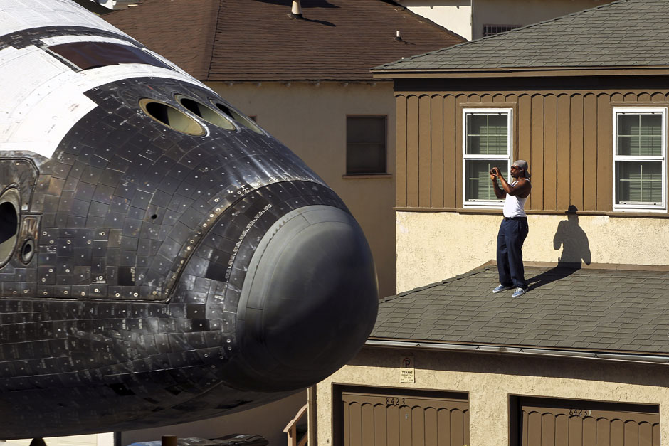 A man takes a photo as Space Shuttle Endeavour travels to the California Science Center in Inglewood, Los Angeles