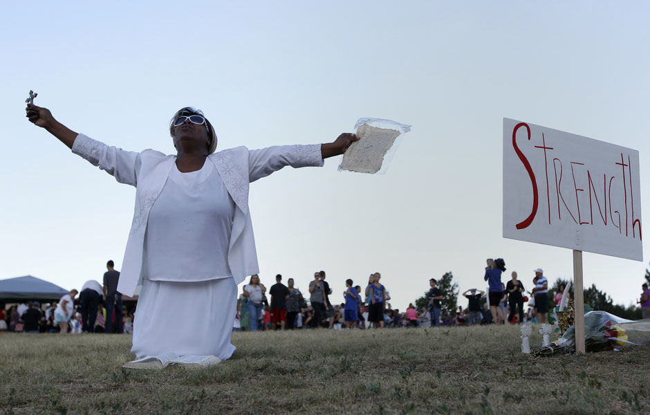 Perkins prays during a vigil for victims behind the theater where a gunman opened fire in Aurora, Colorado