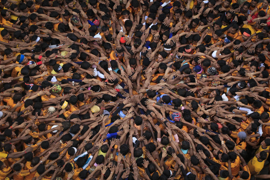 Devotees try to form a human pyramid to break a clay pot containing curd during the celebrations to mark the Hindu festival of Janmashtami in Mumbai