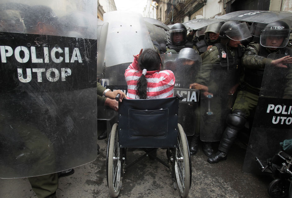A physically disabled woman on her wheelchair clashes with riot police in the centre of La Paz