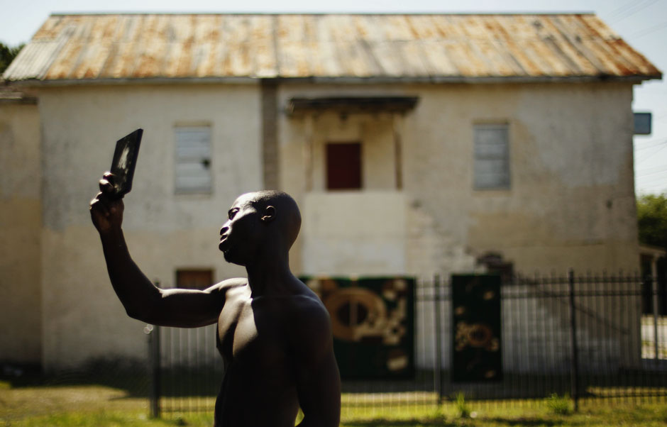 Deontae Mobley looks in the mirror after having his hair cut by his father in the neighbourhood of Goldsboro in Sanford