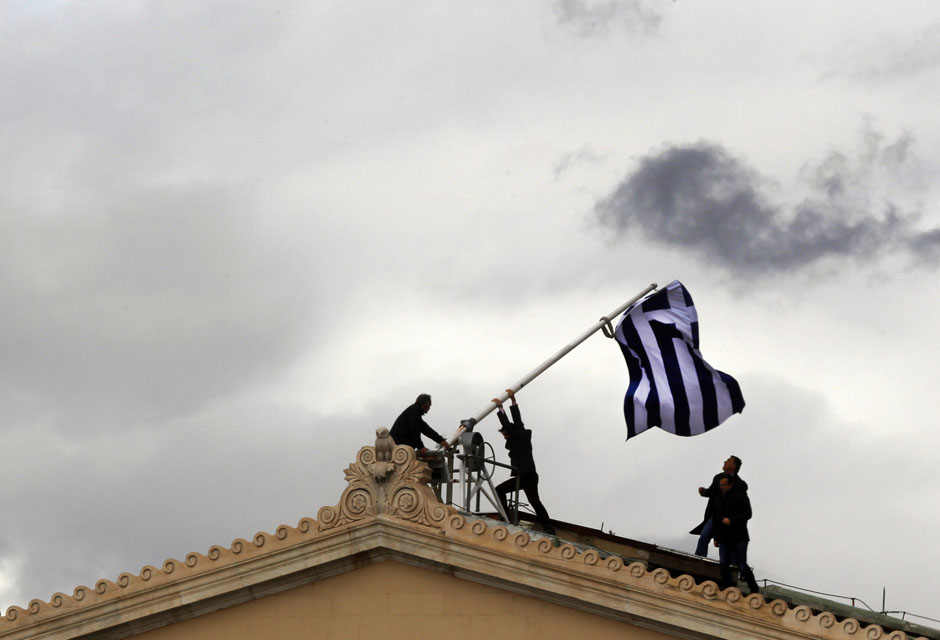 Parliament employees raise flag atop the parliament in Athens