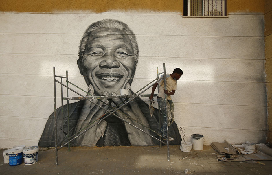 Tavares works on a graffiti of Nelson Mandela which he painted during festivities in his neighborhood in Lisbon