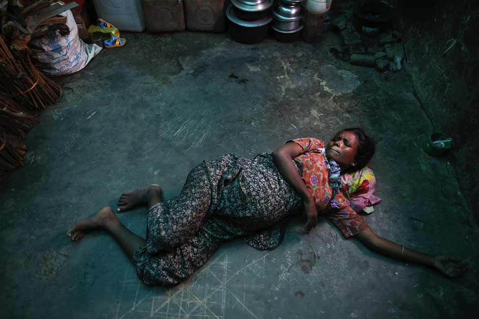 A pregnant Rohingya Muslim woman grimaces while experiencing labour pains at a shelter near Sittwe