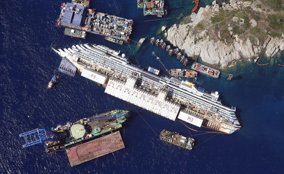 An aerial view shows the Costa Concordia as it lies on its side next to Giglio Island taken from an Italian navy helicopter
